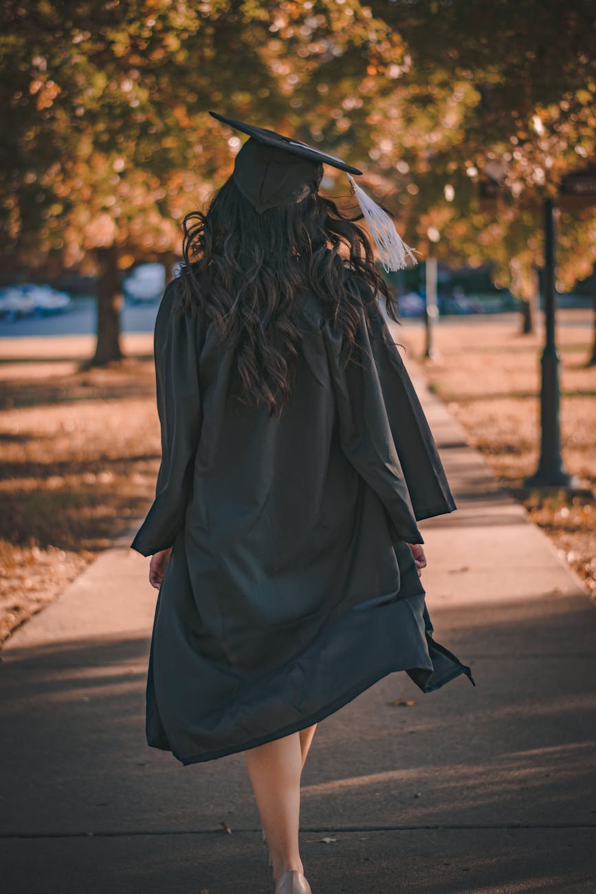 Almost 1.8m people owe £50,000 or more in student debt 1 woman in black long sleeve dress standing on brown concrete pathway